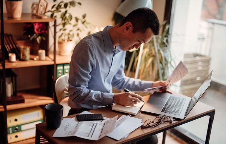 Business professional in a home office using a laptop computer.