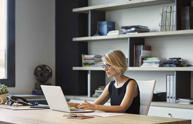 Business professional using a laptop at their desk.