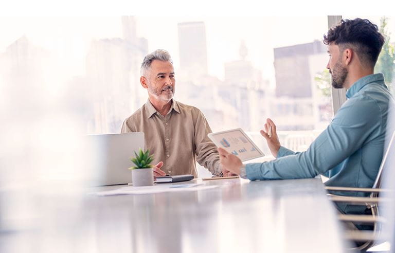 Two business professionals discussing with one another at a table.