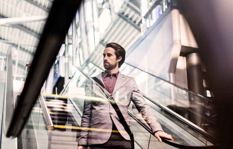 Photo of a business professional going down an escalator.