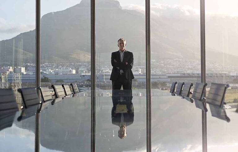 Business executive standing in front of a conference room table.