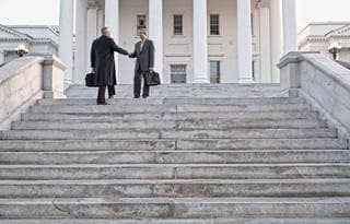 Two business professionals walking up a set of concrete steps.