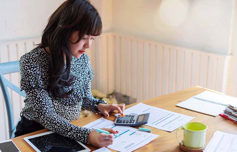 Business professional using a calculator at their desk.