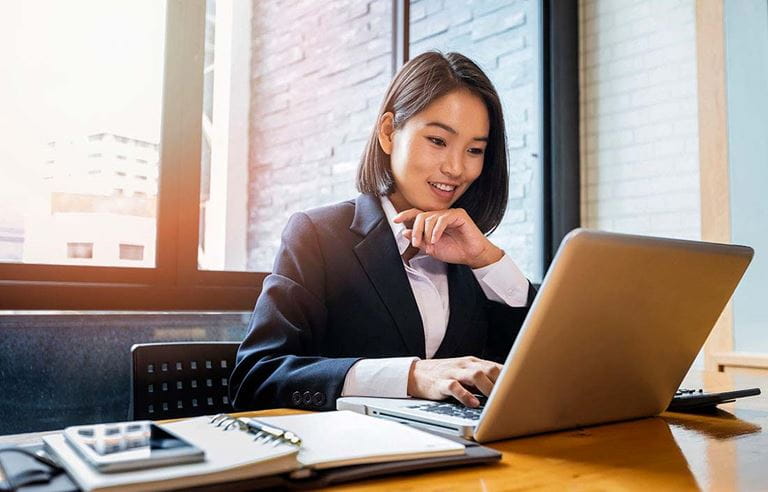 Business professional checking their laptop computer.