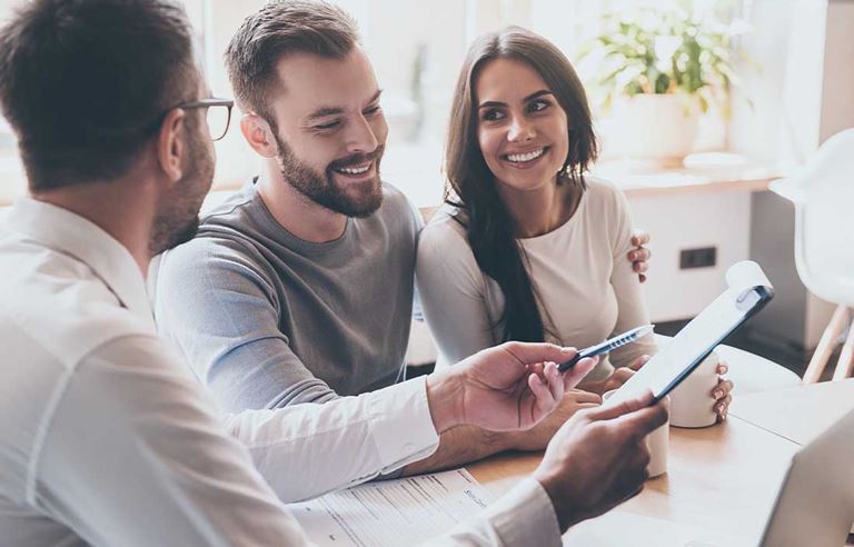 Wealthy couple evaluating their current financial plan with an advisor.