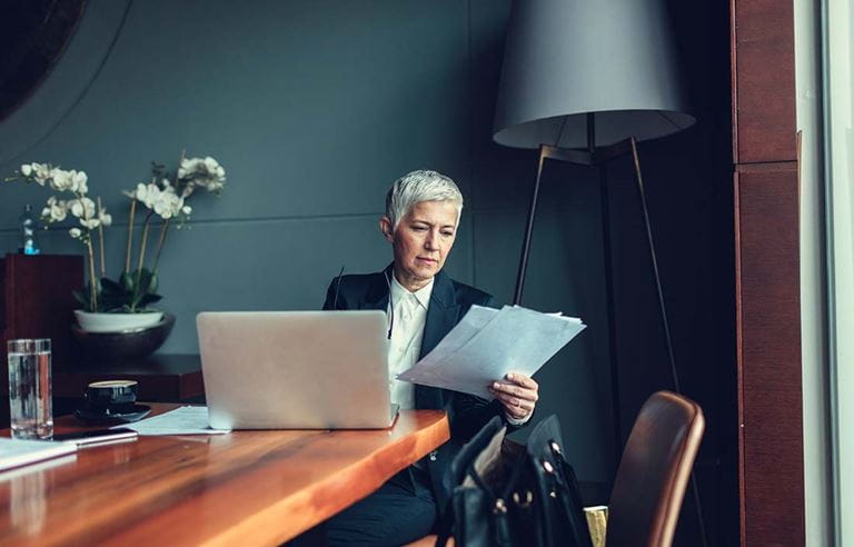 Person looking at work documents and their computer.