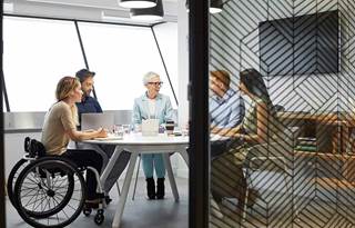 Business professionals meeting around a table discussing risk, opportunity, and growth.
