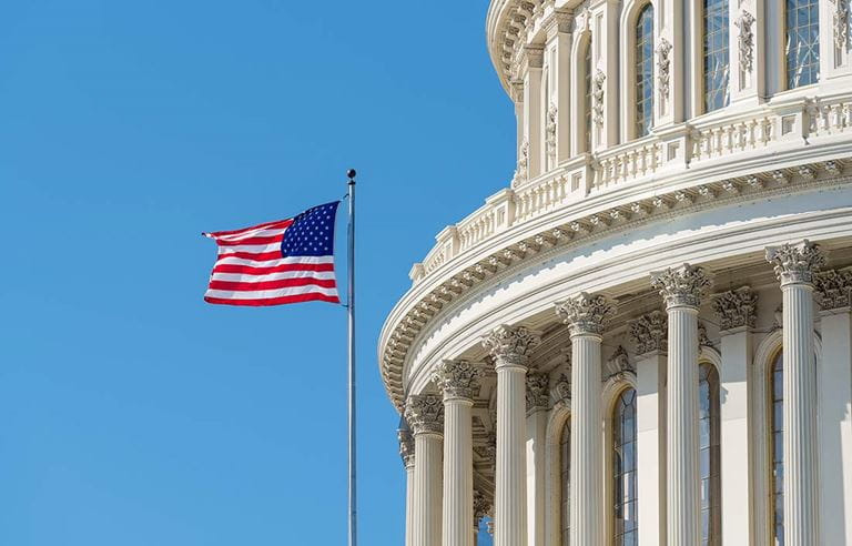 View of American flag next to government building.