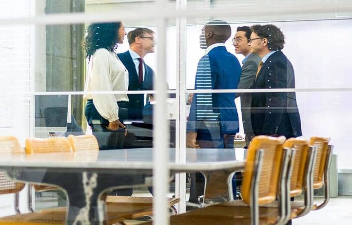 Group of business professionals in a modern conference room meeting and discussing nontraditional lenders.