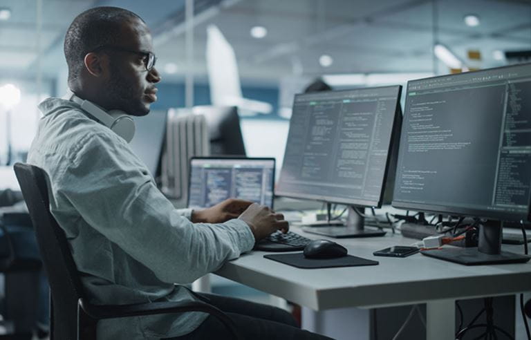 Cybersecurity professional sitting at a desk using a computer