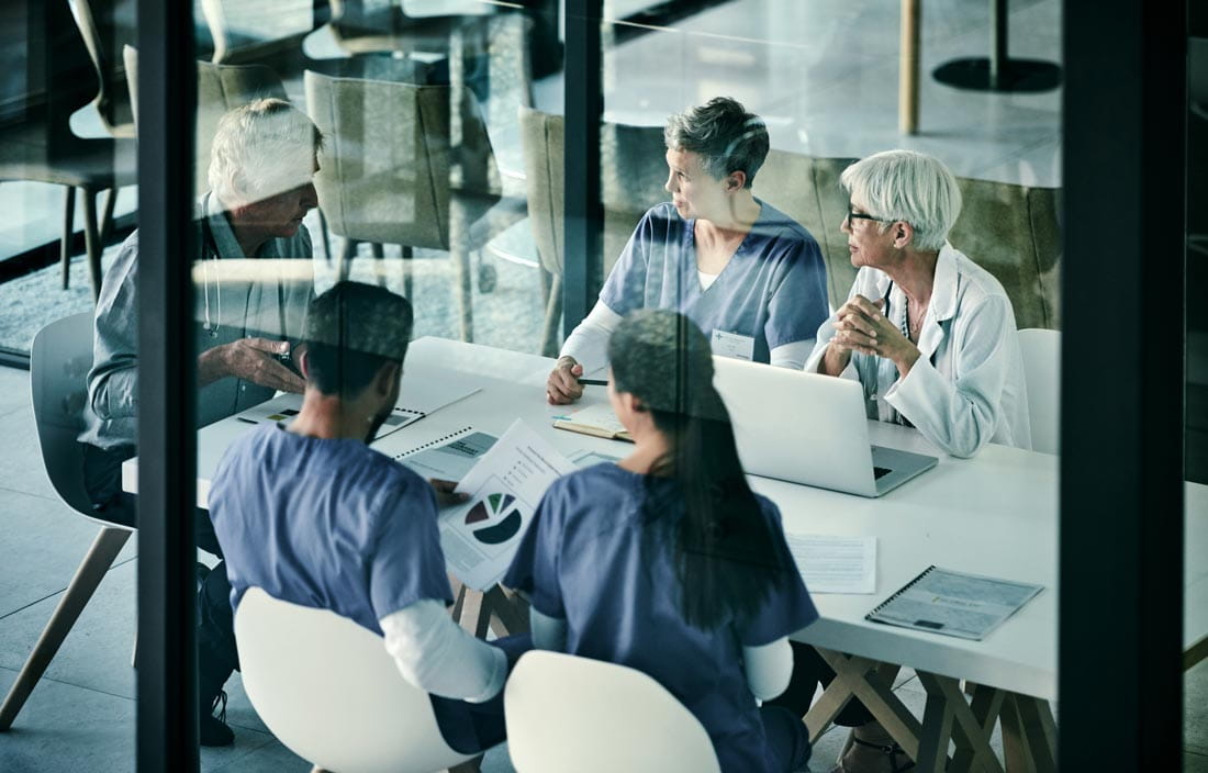 Healthcare workers sitting at a table having a meeting