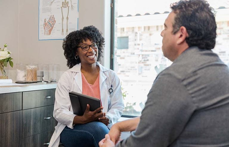 Medical professional speaking with their patient in a doctor's office.