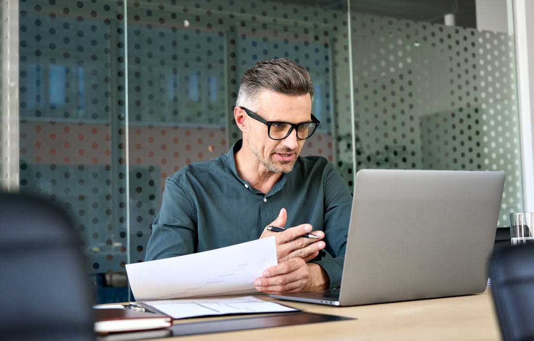 Employee benefits consultant reviewing 2025 retirement plan limitations on their laptop.