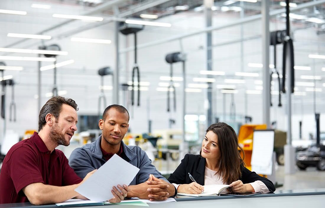 Business professionals holding documents and discussing with one another while sitting down