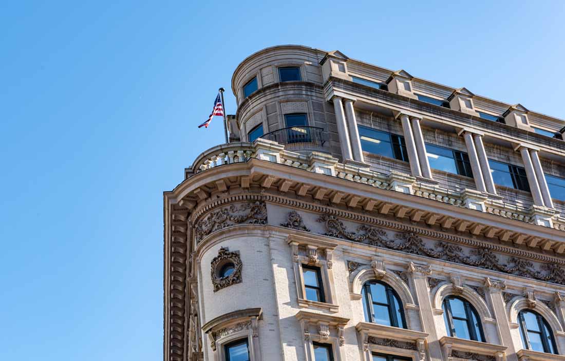 Close up view of an old building with an American flag at the top of the building