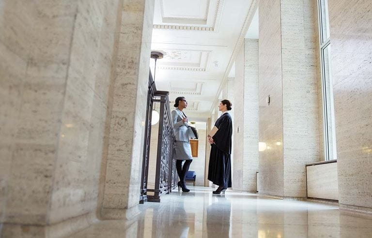 Two tax professionals talking in a government building.