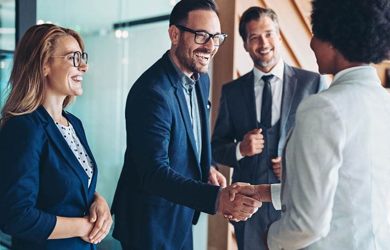 Two business professionals shaking hands and smiling