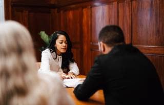 Two business professionals sitting at a table discussing share based payments