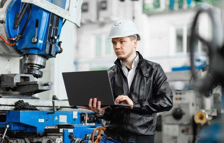 Plastics professional on their laptop in a factory.