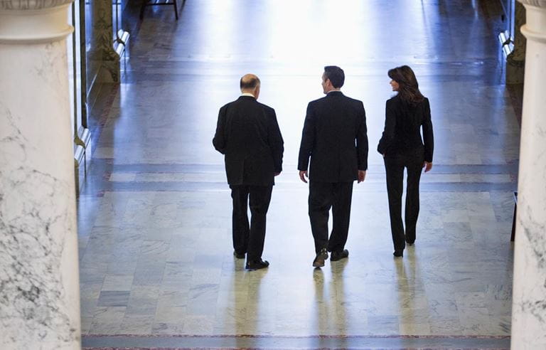 Three tax professionals talking in a government building.