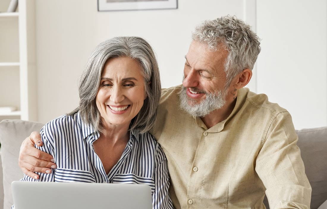 Man and women smiling at computer while discussing silent trusts