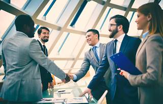 Business professionals shaking hands during a sale.