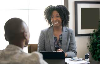 A financial advisor talking to client in a conference room.