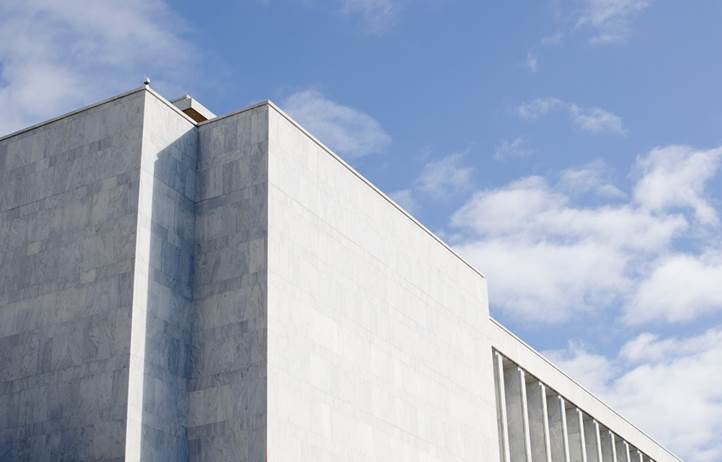 Concrete building's roof against the blue sky.