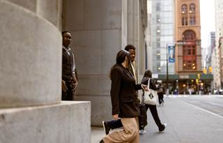 Tax experts walking out of an office building onto a city street.