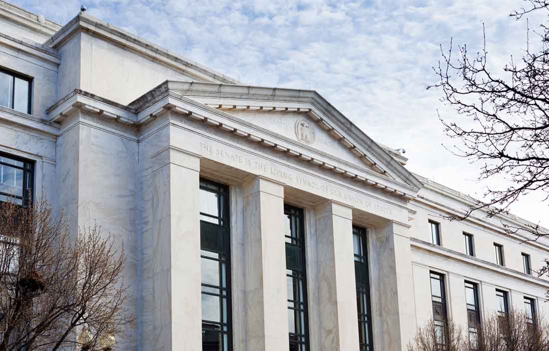 Government building facade against a cloudy sky.