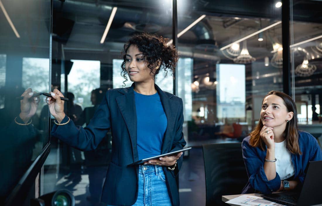 ERP consultants writing on a whiteboard in a conference room.