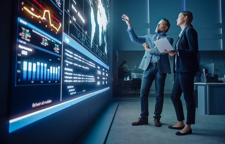 Financial professionals looking at charts on a monitor.