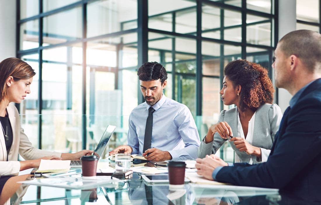 Group of private equity professionals gathered in a modern conference room.