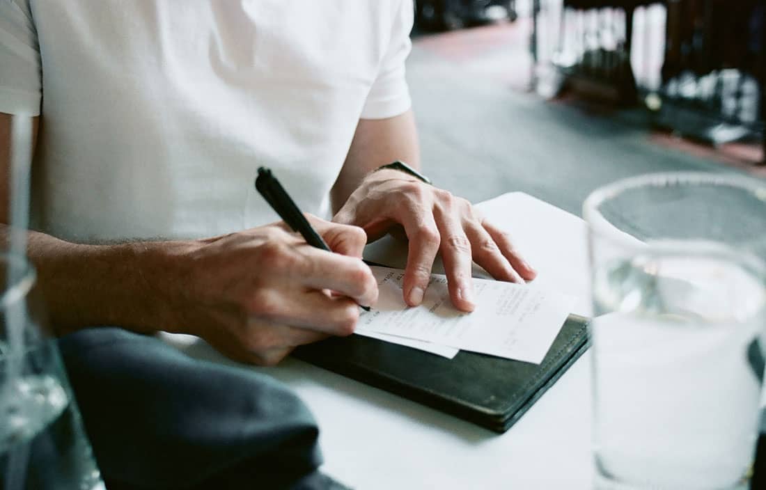 Close-up view of a person signing a bill