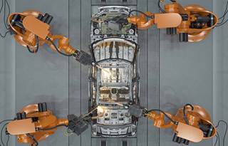 Overview of automobile being worked on at a factory.