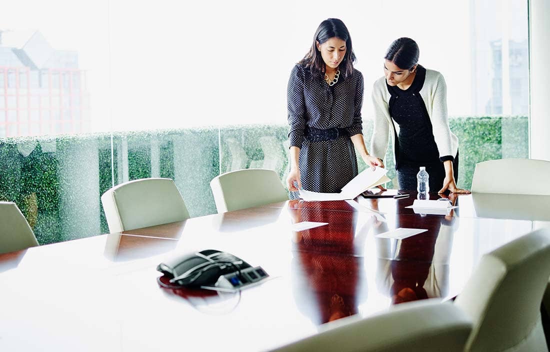 Two business professionals working in a conference room.