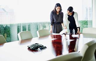 Two business professionals working in a conference room.