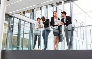 Regulatory compliance professionals standing in a modern office building and talking.