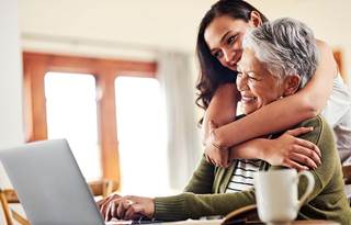 Mother and their adult child hugging.