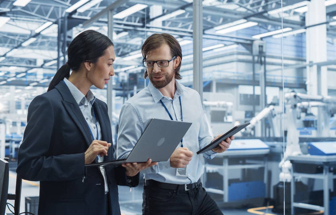 Two professionals discussing inventory in smart manufacturing.