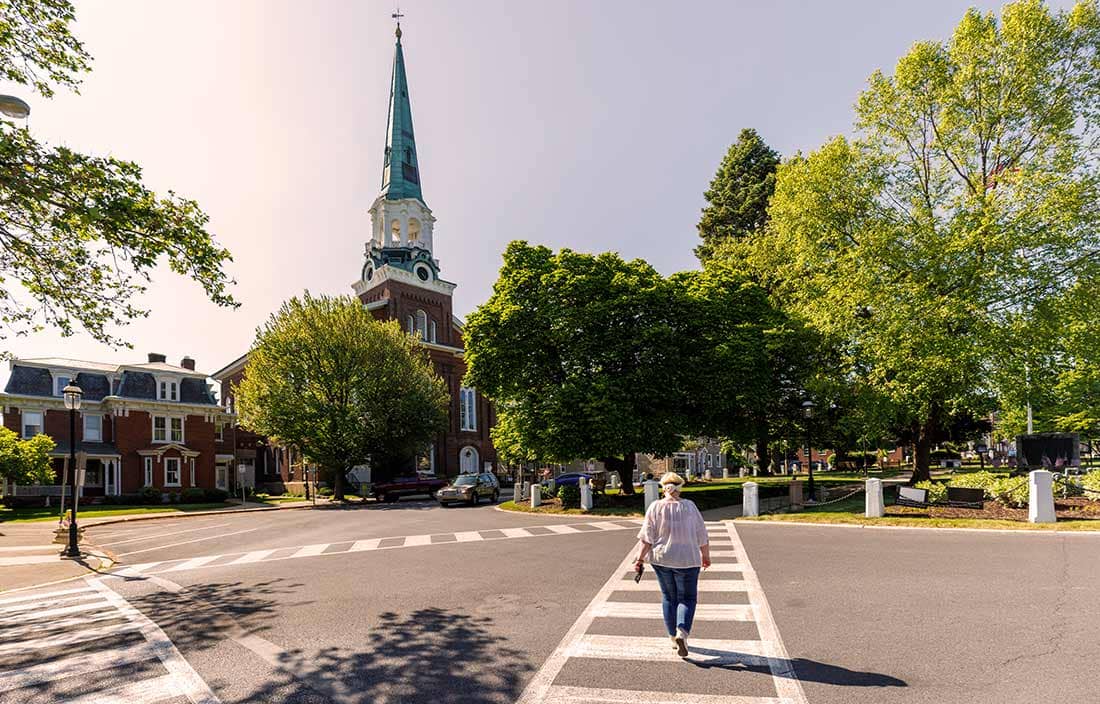 Person walking in a crosswalk to a church.