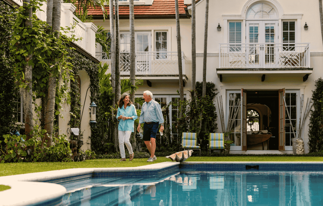 Senior couple walking alongside a pool.