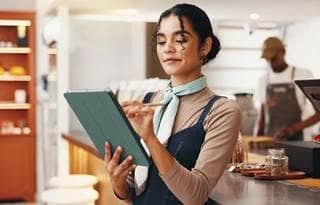 Restaurant owner reviewing information on their tablet.