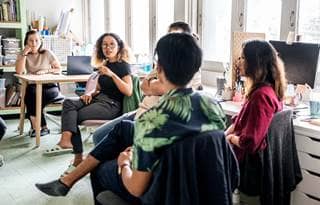 Group of nonprofit professionals discussing cost-saving trends.