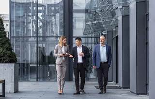 Employee benefits professionals walking outside of an office.