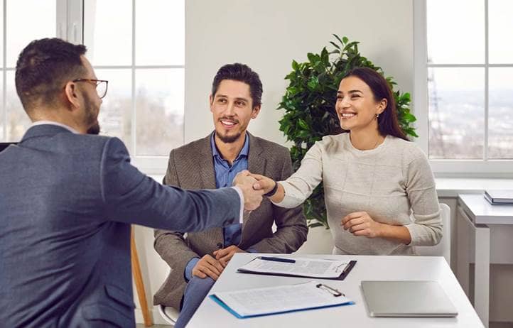 Wealthy couple shaking hands and talking to their financial advisor.