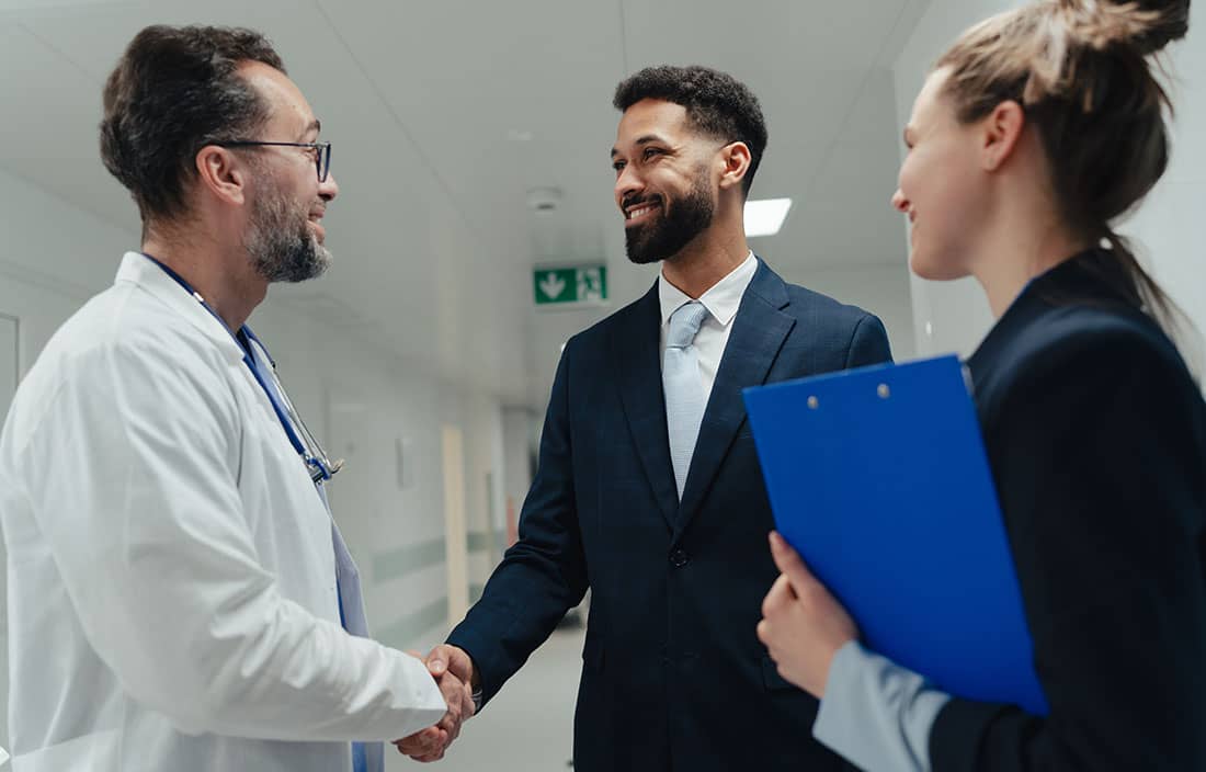 Business professionals shaking a doctors hand