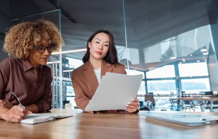 Two business professionals working together to review a report.