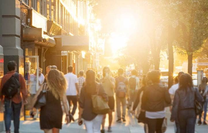 People walking around on a sunny street.