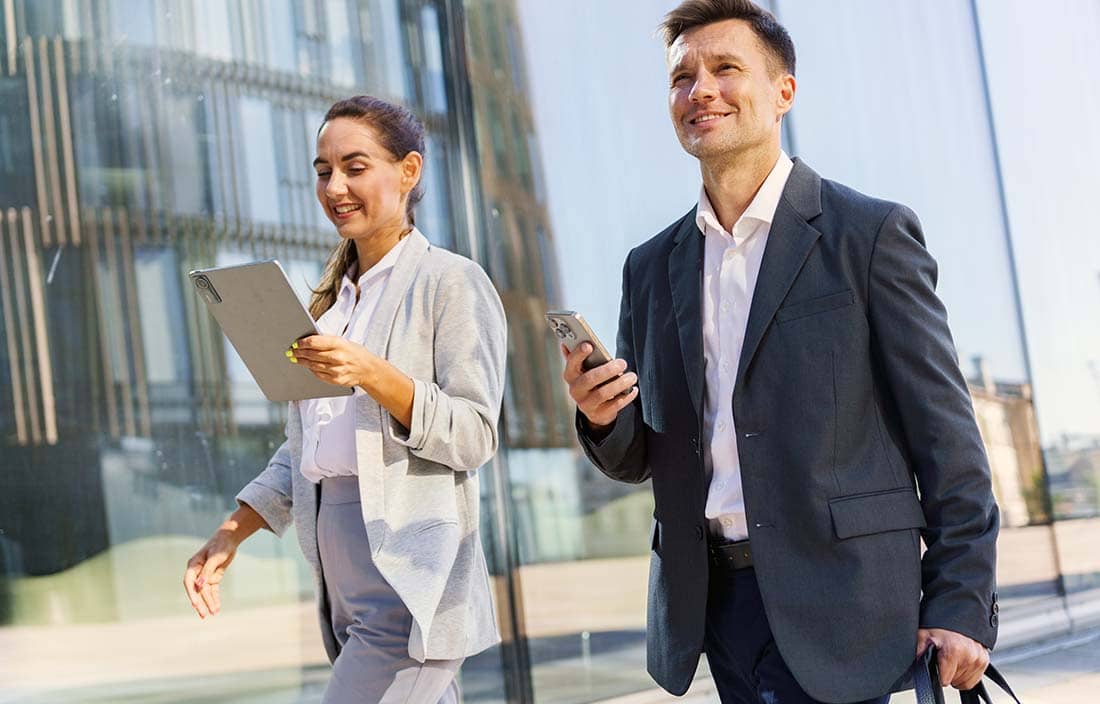 Two business professionals walking outside of an office.
